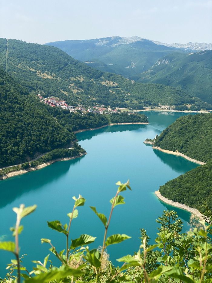 Captivating aerial view of lush mountains and a meandering river in Montenegro, showcasing natural beauty.
